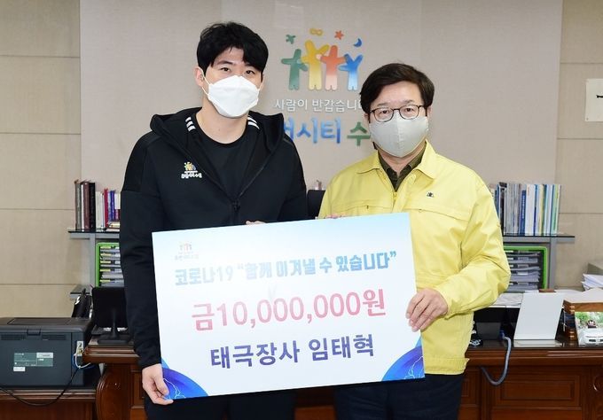 임태혁 씨름선수(왼쪽)가 염태영 수원시장(오른쪽)에게 기부금 1000만 원을 전달한 후 함께하고 있다