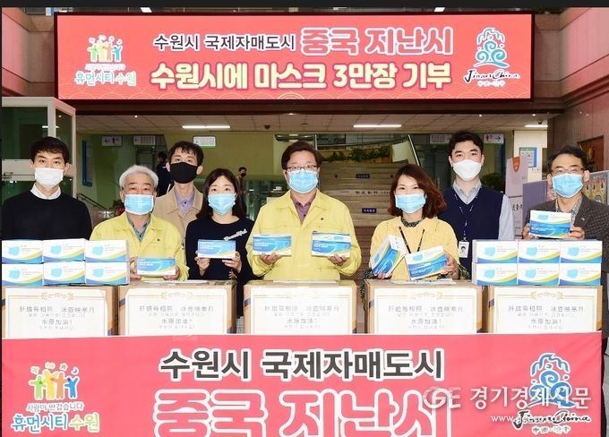 염태영 시장과 공직자들이 지난시에서 보낸 마스크 상자를 앞에 두고 기념촬영을 하고 있다. / 사진제공 = 수원시청