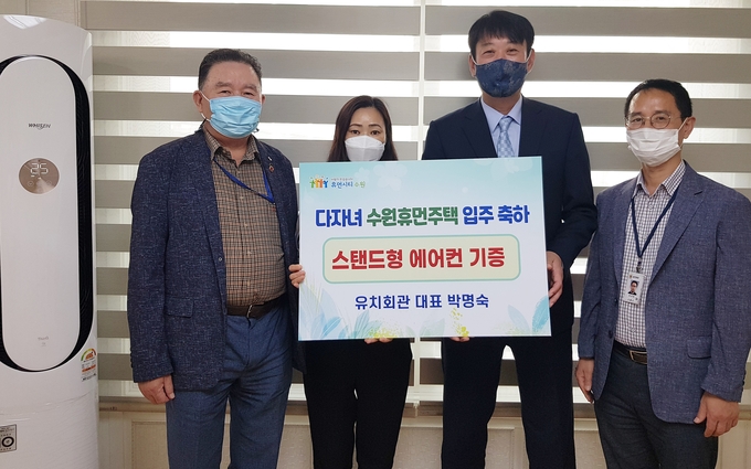 유치회관 직원 노은숙씨(왼쪽 2번째)가 에어컨을 전달하고 기우진 수원시 도시정책실장(오른쪽 2번째) 등 수원시 직원들과 함께하고 있다.