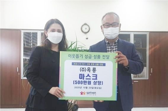 ㈜옥룡 김대근 회장이 (사)위드인 사람과함께 유서진 대표에게 500만원 상당 마스크를 전달하고 있다.