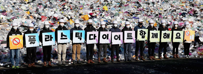 19일 오전 수원시자원순환센터 플라스틱 야외적치장에서 수원도시공사 임직원들이 ‘고고 릴레이’ 캠페인의 일환으로 ‘플라스틱 다이어트 함께해요’란 글이 새겨진 피켓을 선보이는 퍼포먼스를 하고 있다. / 사진=수원도시공사 제공