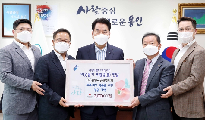 백군기 용인시장이 20일 코로나19 극복을 위해 성금 200만 원을 기탁한 (사)용인시관광협의회 관계자들과 기념촬영을 하고 있다