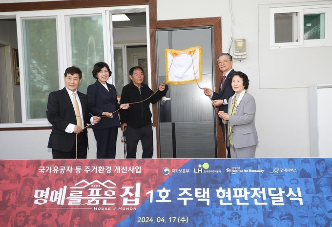 <strong>17일(수) 이한준 LH 사장(왼쪽 네 번째)과 강정애 국가보훈부 장관(왼쪽 두 번째), 윤형주 한국해비타트 이사장(왼쪽 첫 번째), 이호균 굿네이버스 이사장(왼쪽 다섯 번째) 등이 청주시 오송읍에서 진행된「명(예를) 품(은) 집」 1호 주택 현판식에 참석해 행사를 진행하고 있다.</strong>
