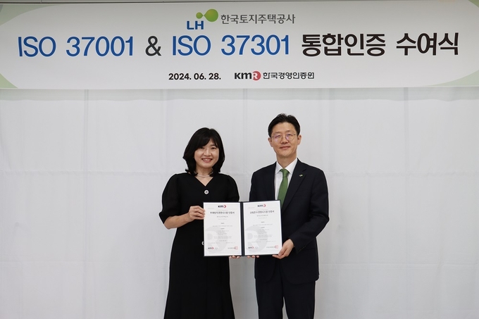 <strong>황은주 한국경영인증원 대표이사(왼쪽)와 이상욱 LH 부사장(오른쪽)가 ISO 37001·37301 인증 취득 기념촬영을 하고 있다.</strong>