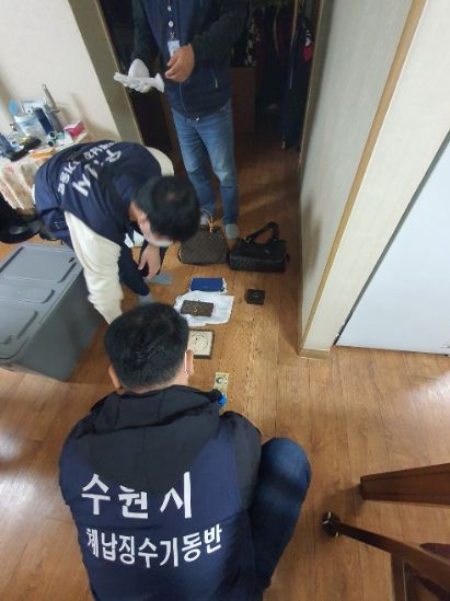 체납징수기동반 직원들이 체납자의 집을 수색하고 있다