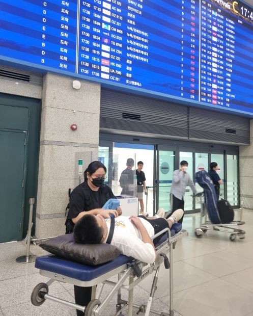 25일 환자이송침대에 실려 인천국제공항 입국장에 들어서는 백씨 모습