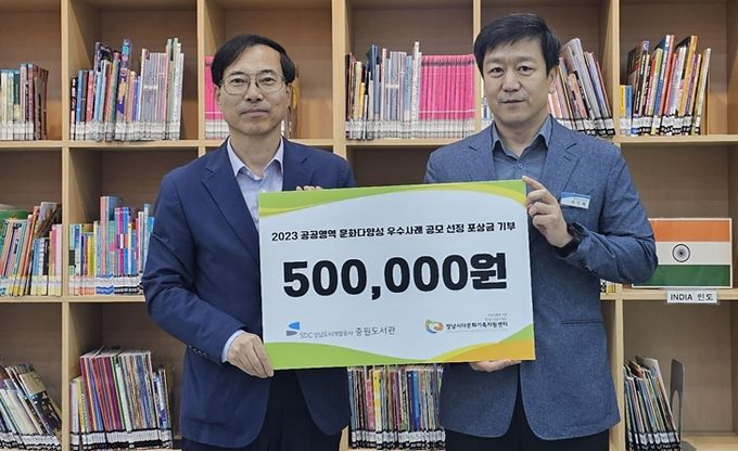 중원도서관 이기태 관장(오른쪽)이 성남시다문화가족지원센터에 기부금을 전달하고 기념촬영을 하고 있다.