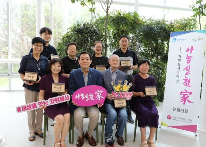 이재준(앞줄 왼쪽에서 2번째) 수원시장과 우수자원봉사자들이 25일 수원시청 새빛민원실에서 문패 전달식을 가진 뒤 기념촬영을 하고 있다.