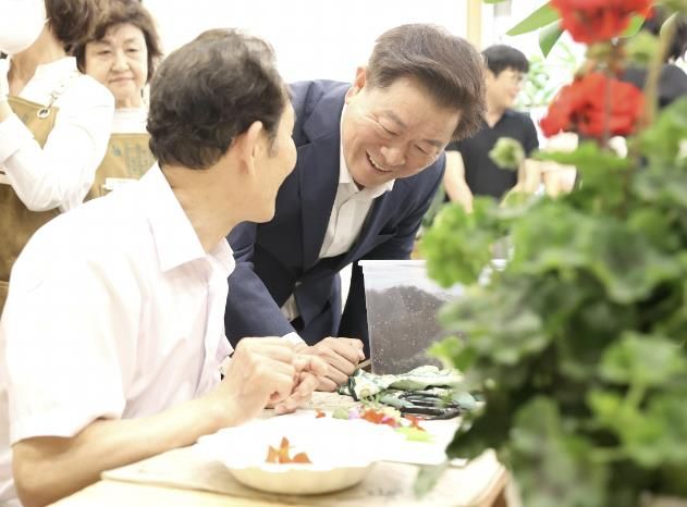 2023년 5월 개최된 '인생정원 개소식'에서 박승원 광명시장이 '초록마루' 공간에서 원예모임 활동을 하고 있는 어르신께 인사하고 있다