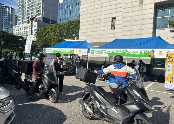 배달노동자 이륜차를 점검하고 있다.