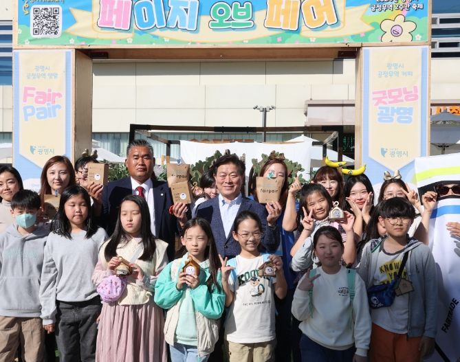 광명시가 지난 26일 청소년수련관 앞 광장에서 열린 공정무역 축제 개막행사 ‘페이지 오브 페어(Page Of Fair):공정함의 새로운 페이지를 열다’에서 광명시 공정무역 육성 사업의 첫 번째 결과물인 ‘공정무역 커피 5종’과 ‘공정무역 양말 6종’을 공개했다. 사진은 박승원 광명시장이 새로 출시된 광명형 공정무역 제품을 들고 행사 참석자들과 기념사진을 촬영하는 모습.