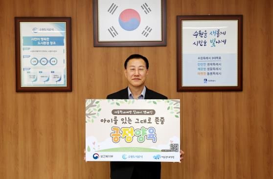 허정문 수원도시공사 사장이 18일 오전 더함파크 집무실에서 ‘아이를 있는 그대로 존중 긍정 양육’이 적인 피켓을 들고 아동학대예방 릴레이 캠페인’에 동참하고 있다. (사진=수원도시공사 제공)