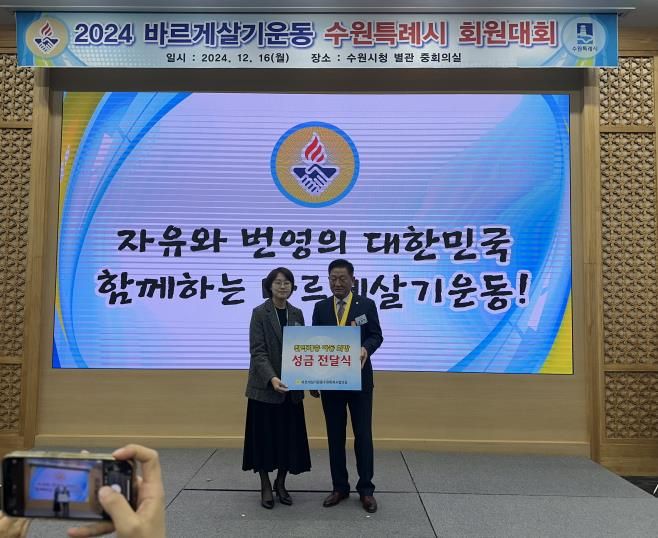 12월 16일 2024 바르게살기 운동 수원특례시 회원대회에서 유재명 바르게살기운동 수원특례시협의회 회장이 수원시 관계자에게 성금을 전달하고 있다.