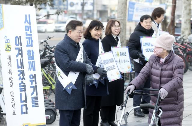 박승원 광명시장이 24일 아침 철산역 2번 출구 앞에서 광명시 출자·출연기관 기관장들과 함께 시민들에게 새해 인사를 건네고 있다.