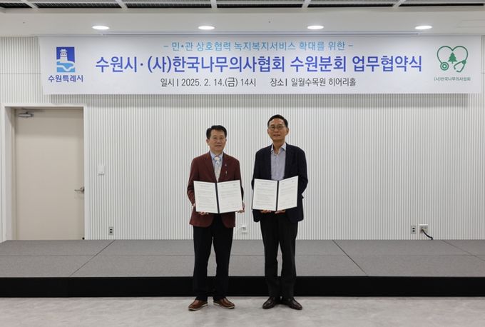 최재군 수원시 공원녹지사업소장(왼쪽)과 조성칠 한국나무의사협회 수원시분회장(오른쪽)이 협약식 이후 기념 사진을 촬영하고 있다.
