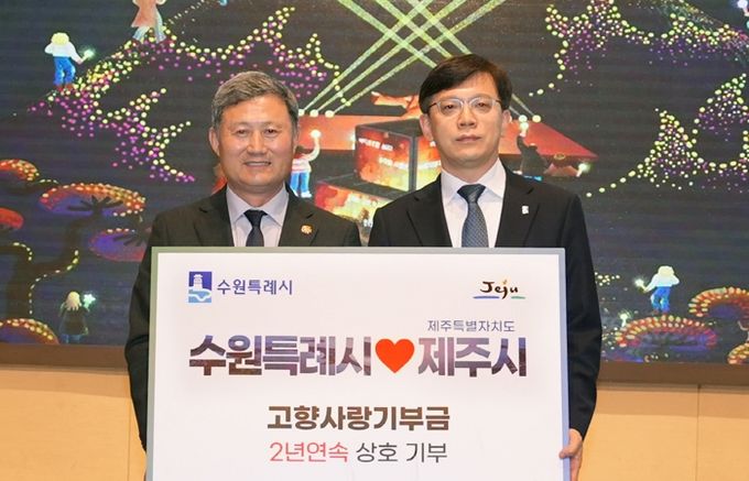 현근택 수원시 제2부시장(오른쪽)과 김완근 제주시장이 고향사랑 상호기부식 후 함께하고 있다.