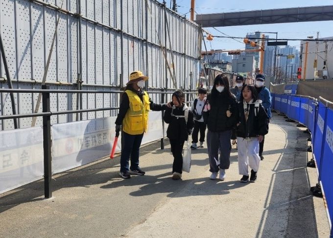 안전보안관이 트리우스광명아파트 인근 통학로에서 초등학생들의 안전한 통학을 돕고 있다.