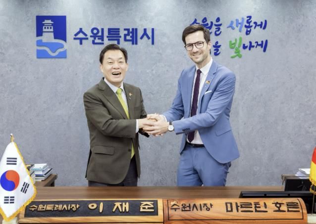 이재준 수원시장이 마르틴 호른 프라이부르크시장에게 명예 수원시장 명패를 전달한 후 활짝 웃고 있다.