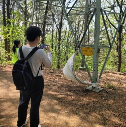 수원시 관계자가 국가지점번호판을 조사하고 있다.