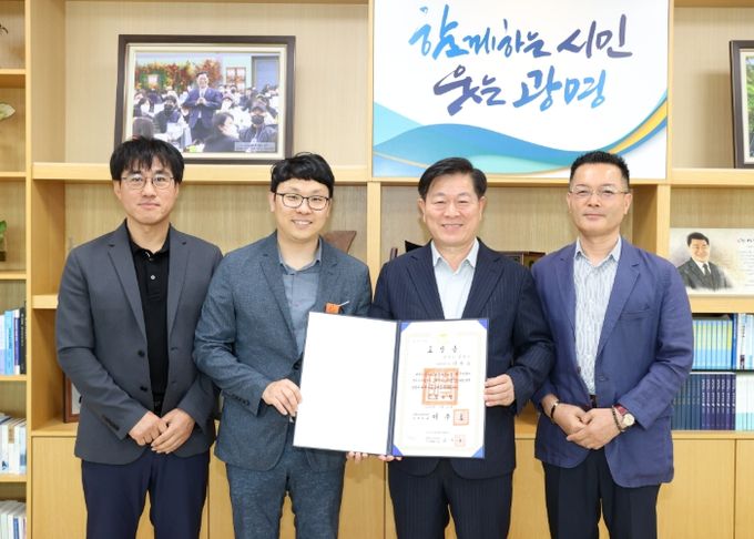 박승원 광명시장(사진 왼쪽에서 세 번째)이 정부를 대신해 이현우 주무관(사진 왼쪽에서 두 번째)에게 근정포장을 전달한 후 기념 촬영을 하고 있다.
