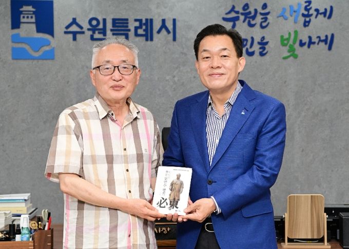 이재준 수원시장(오른쪽)과 박환 고려학술문화재단 이사장(왼쪽)이 평전을 들고 기념 촬영을 하고 있다.