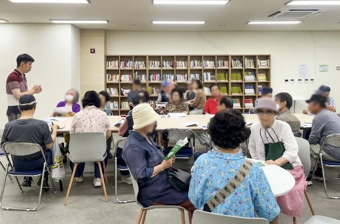 수원시 관계자가 지난 22일 어르신들을 대상으로 ‘똑버스’ 이용법을 안내하고 있다