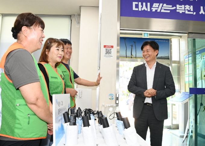 조용익 부천시장이 원종1동 행정복지센터를 찾아 양우산 대여 봉사를 하고 있는 자율방재단에게 격려의 말을 전하고 있다.